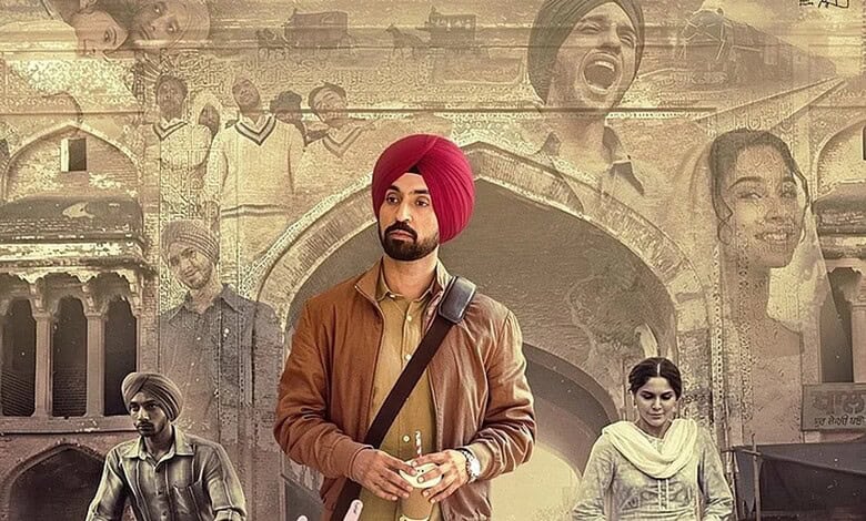 Young man in a brown leather jacket and red turban standing in front of historic architecture.