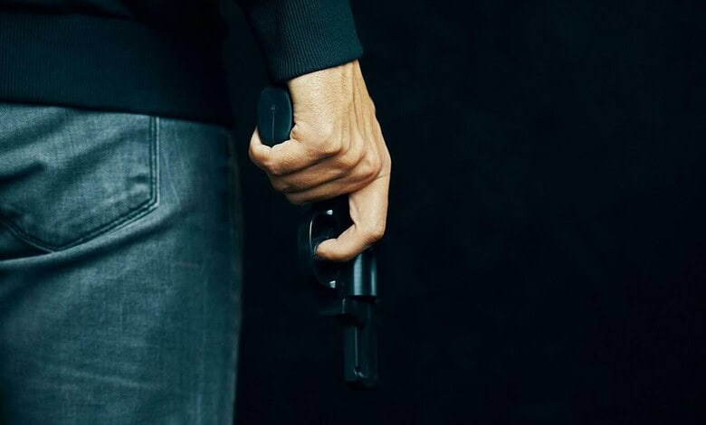 Close-up of a man holding a handgun in his right hand at Lulu Mall parking lot.