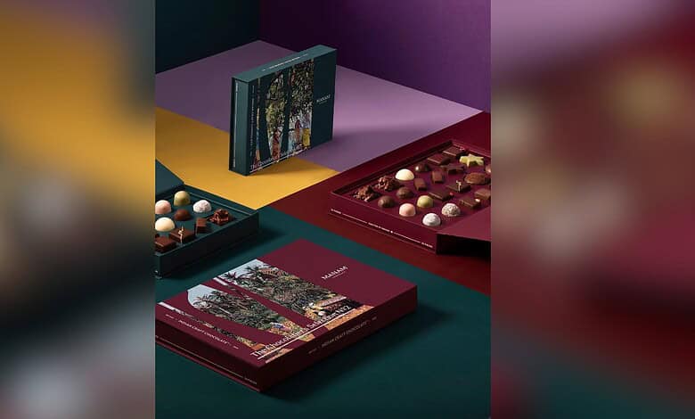 Assorted chocolates and packaging on colourful background, celebrating craft chocolate awards.