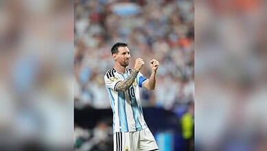 Lionel Messi celebrating on the football field in his Argentina national team jersey.