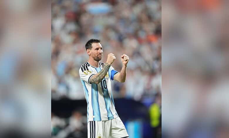 Lionel Messi celebrating on the football field in his Argentina national team jersey.