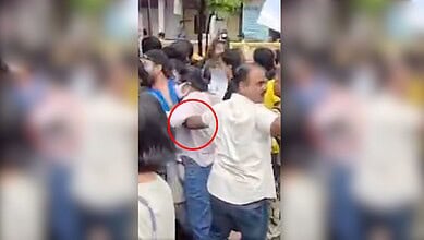 Crowd gathered around a police officer and a woman during a public incident in Mumbai.