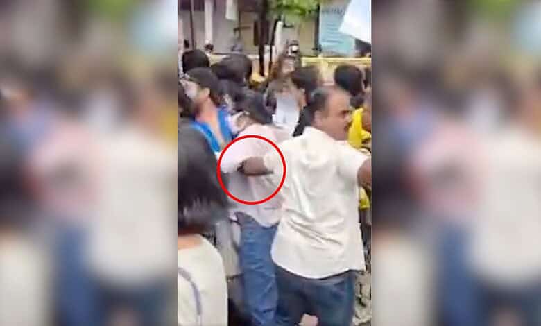 Crowd gathered around a police officer and a woman during a public incident in Mumbai.