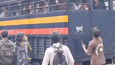 Man helps detained students escape from police van in a crowded street scene.