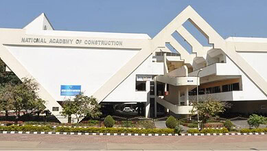 Modern white building of the National Academy of Construction with geometric design.