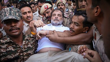 Man being forcibly removed by police and protesters during Telangana bandh protest.