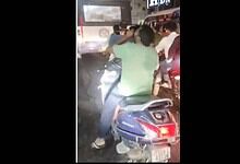 Man riding a two-wheeler while drinking alcohol in Hyderabad, captured at night.