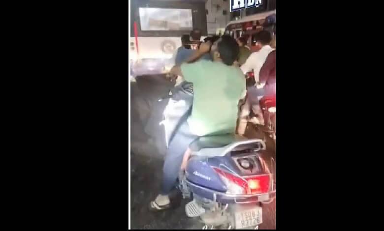 Man riding a two-wheeler while drinking alcohol in Hyderabad, captured at night.