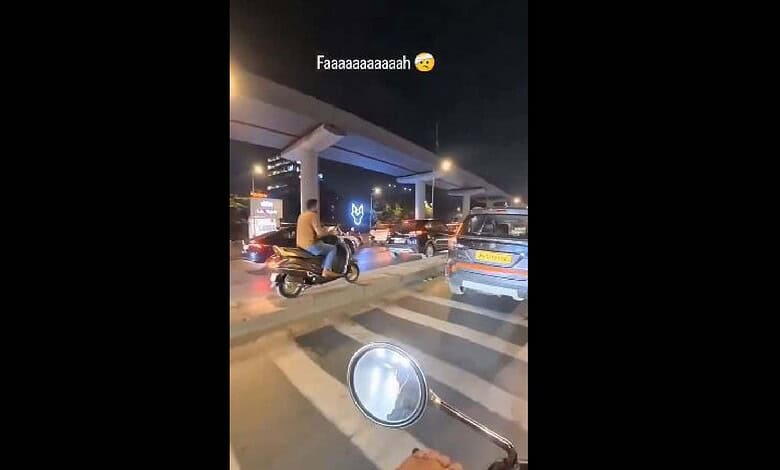 Motorcyclist riding without helmet at Hyderabad traffic signal at night.