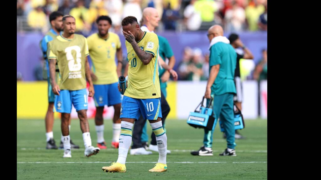 Norwegian footballer Erling Haaland looks disappointed after a match, with teammates in the background.