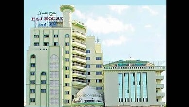 Modern building with a minaret and a dome, labeled 'Haj House' in Hyderabad, India.
