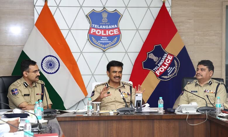 Telangana police officials in a meeting with Indian flags and police emblems in background.