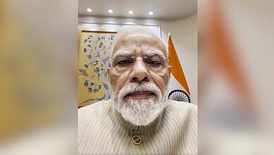 Close-up of Indian Prime Minister Narendra Modi with Indian flag in background.