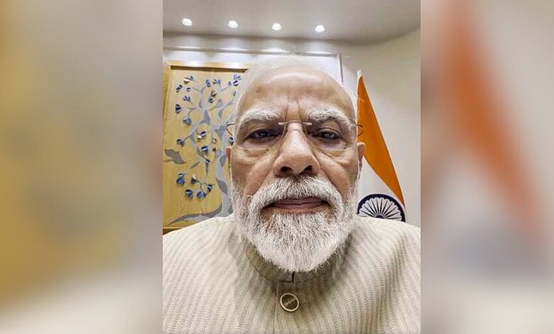 Close-up of Indian Prime Minister Narendra Modi with Indian flag in background.