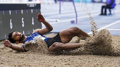 Sreeshankar lands in the sand during a long jump at the Commonwealth Games.
