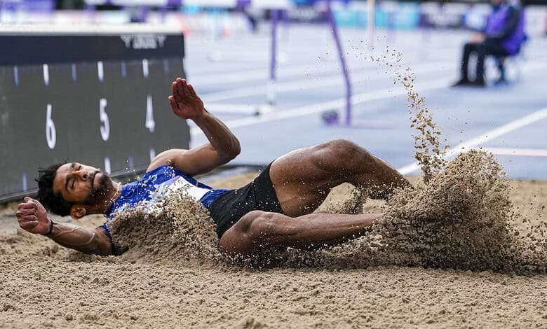 Sreeshankar lands in the sand during a long jump at the Commonwealth Games.