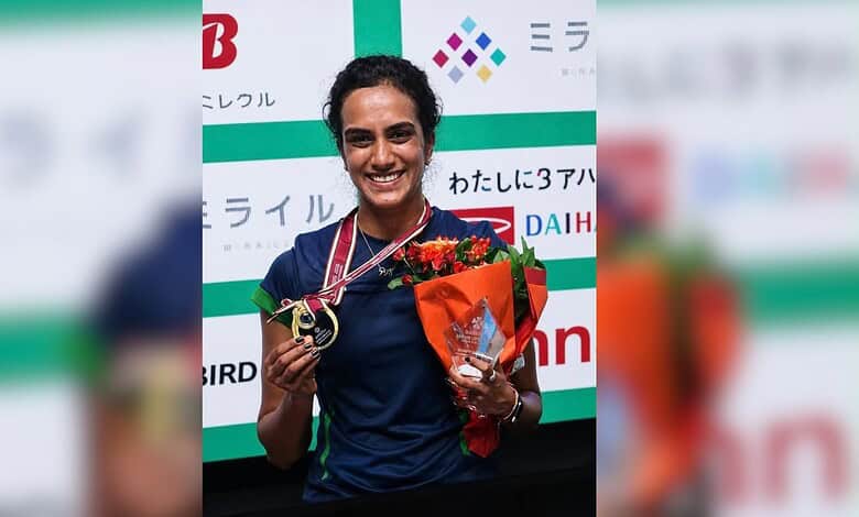 PV Sindhu holding a bouquet and medal at the Japan Open victory celebration.