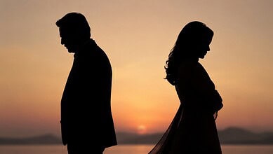 Silhouettes of a man and woman facing away at sunset, symbolising relationship issues.