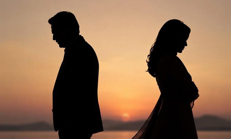 Silhouettes of a man and woman facing away at sunset, symbolising relationship issues.
