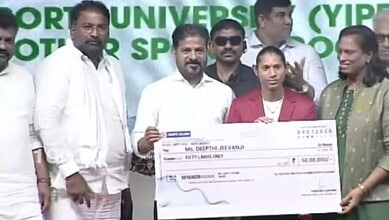 Telangana officials and CM Revanth holding a cheque at a sports event.