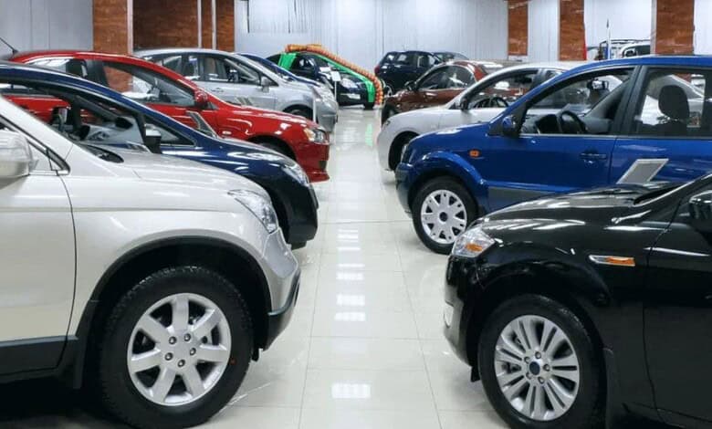 Variety of new cars displayed in a spacious indoor showroom for sale.
