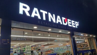 Exterior view of Ratnadeep supermarket with visible logo and interior shelves stocked with dairy products.