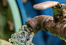 Close-up of a water tap releasing water, with a blurred background.