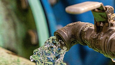 Close-up of a water tap releasing water, with a blurred background.