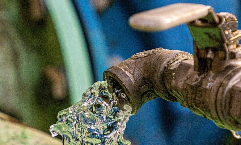 Close-up of a water tap releasing water, with a blurred background.