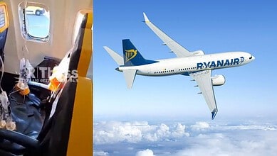 Ryanair airplane flying high above clouds in clear blue sky.