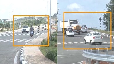 Vehicles and motorcycles on a busy road with a pedestrian crossing and guardrails.