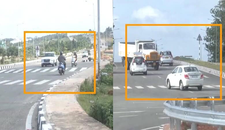 Vehicles and motorcycles on a busy road with a pedestrian crossing and guardrails.