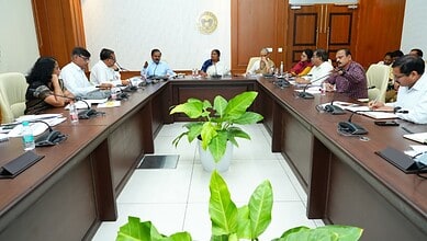 Government officials and leaders in a meeting room discussing water supply to rural areas.