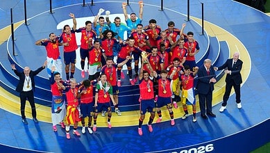 Spain's football team celebrates winning the FIFA World Cup with medals and trophies.