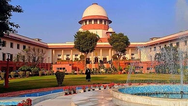 Supreme Court of India building with gardens and fountain in front, under clear blue sky.