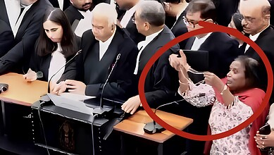 Woman pleads before Supreme Court during a hearing, surrounded by officials and lawyers.