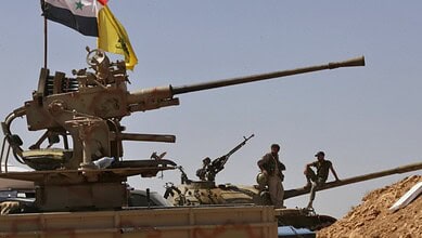 Syrian tanks and soldiers in a desert landscape, possibly related to military operations.