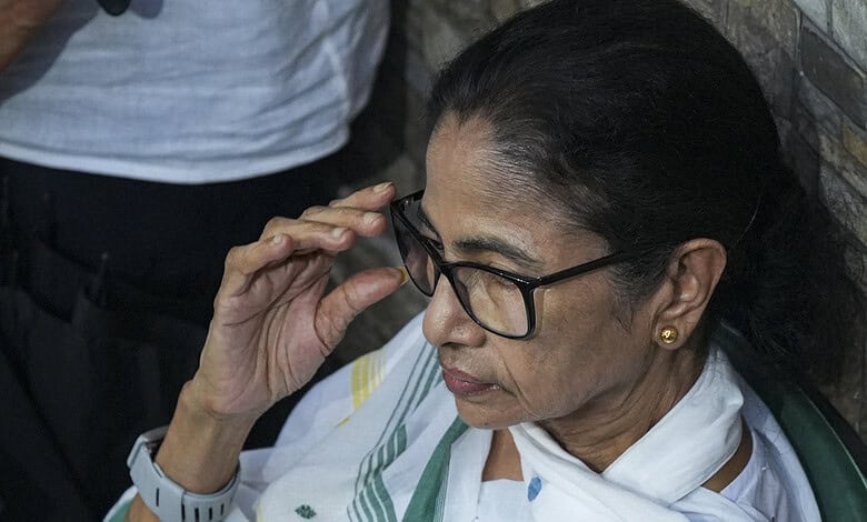 Mamata Banerjee adjusting her glasses during a public event in Kolkata.