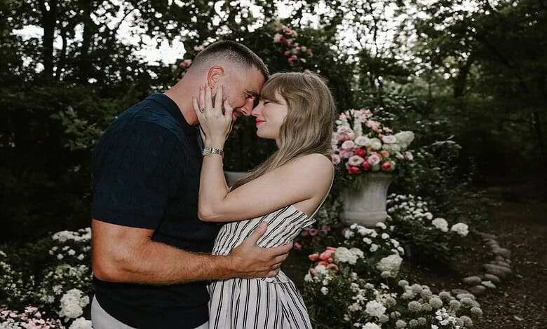 A couple in love touching foreheads in a garden with blooming flowers and greenery.