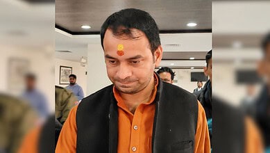 Tej Pratap Yadav at an indoor event, wearing traditional attire with a tilak on his forehead.