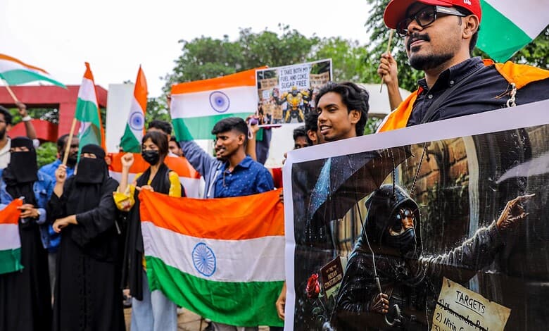 People holding Indian flags and protesting during a rally or demonstration.
