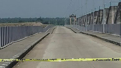 Empty road with concrete barriers and yellow caution tape at Kaleshwaram project site.