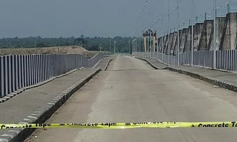 Empty road with concrete barriers and yellow caution tape at Kaleshwaram project site.