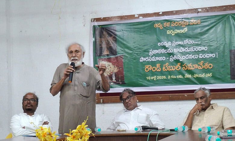 The image shows Adi Dhwani Trust founder and retired professor Jayadheer Tirumala Rao addressing a round-table meeting at Sundarayya Vignana Kendram on Friday, July 10, 2026.