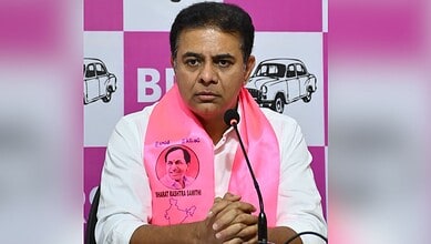 Revanth Reddy at a press conference wearing a pink scarf with his photo and signature.