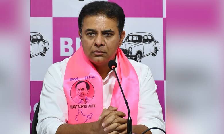 Revanth Reddy at a press conference wearing a pink scarf with his photo and signature.