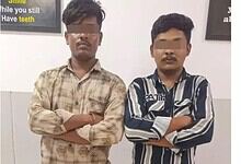 Two young men with crossed arms standing indoors, faces obscured, in Hyderabad.