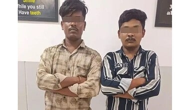 Two young men with crossed arms standing indoors, faces obscured, in Hyderabad.
