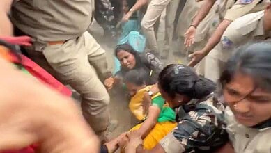 Protesters and police clash during Hyderabad demonstration, chaos and dust in the scene.