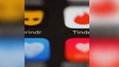 Close-up of dating app icons on a smartphone screen, including Tinder and Grindr.